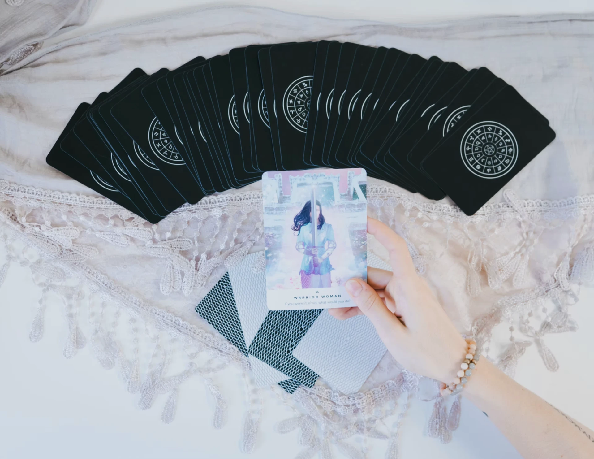 Cartas de Tarot elegantes dispostas sobre tecido claro, em ambiente sereno com luz quente